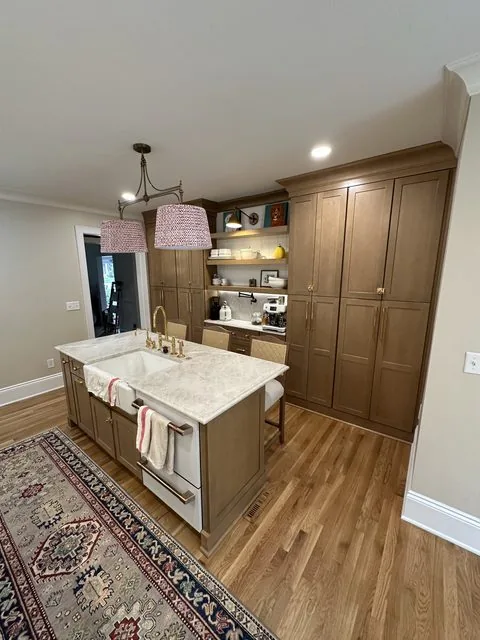 Remodeled kitchen with warm wood cabinetry, island, and woven pendant lighting. 42nd Street, Richmond, VA