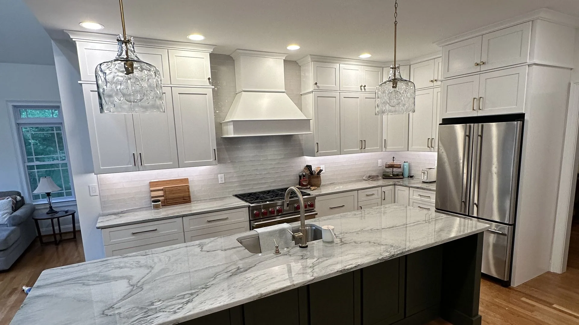 Remodeled kitchen with marble island, glass pendants, and custom cabinetry. Brook Road, Richmond, VA